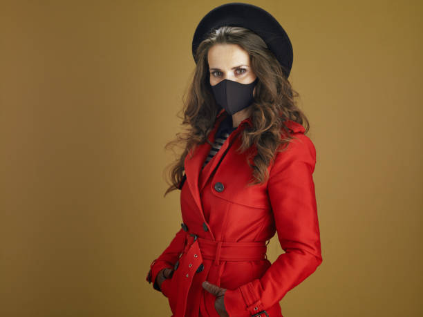 istock young woman in red coat against bronze background 1275883826