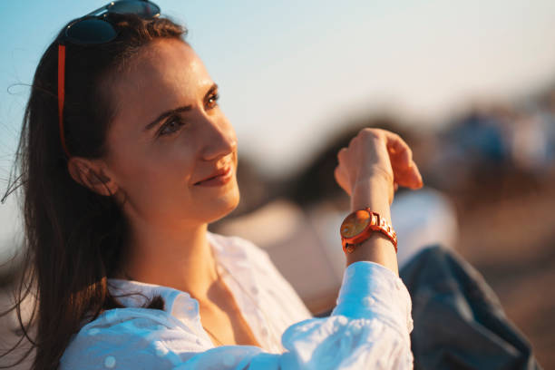 istock Young woman look at her watch at sunset 1275884835