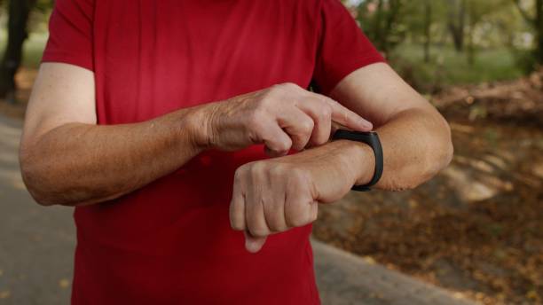 istock Adult runner man starting tapping touchscreen on smart watch, tracking distance, checking pulse 1275885260