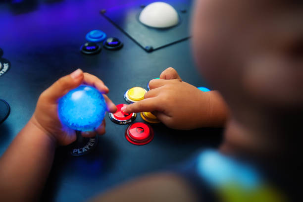 A young boy playing video games on a home arcade with push buttons arranged in a fighter style layout. stock photo