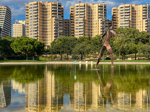 Valencia, Spain - September 20, 2020: Modern buildings reflecting over water in the Turia Garden. This huge public park is an old riverbed that crosses the city and is the biggest in Europe