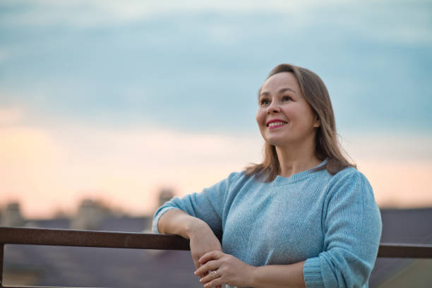 istock Mature woman looking optimistic on the future over evening sky 1275922616