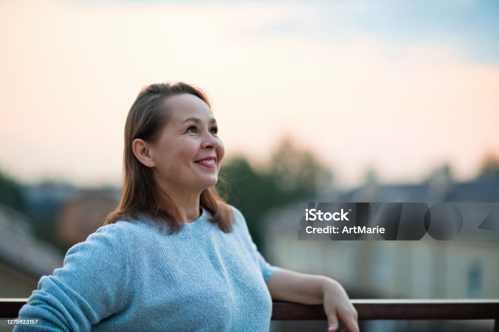 Mature woman looking optimistic on the future over evening sky Woman's portrait with copy space Women Stock Photo