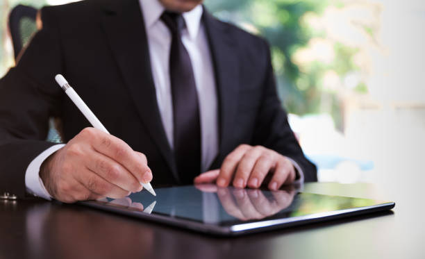uomo d'affari che firma un contratto digitale su tablet utilizzando la penna stilo - digital tablet digitized pen touchpad men foto e immagini stock
