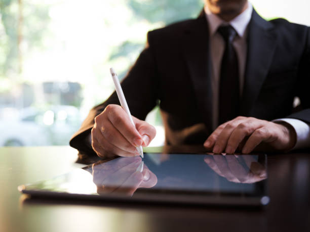 Businessman Signing Digital Contract On Tablet Using Stylus Pen Businessman Signing Digital Contract On Tablet Using Stylus Pen digitized pen photos stock pictures, royalty-free photos & images