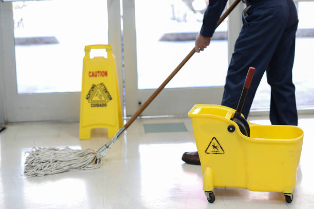 Senior Adult Janitor mops floor at entry to offices. stock photo