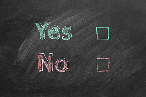 Two voting checkboxes with lettering Yes and No on blackboard. Your choice concept.