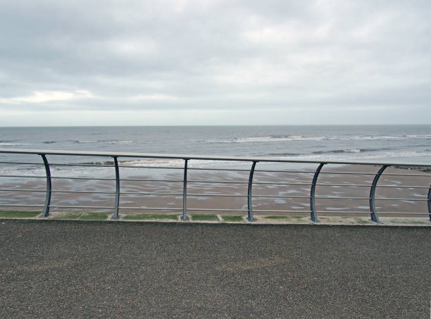 istock metal railings on the seafront in blackpool with waves breaking on the beach under a cloudy sky 1275966033