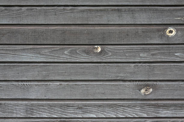 fragmento da parede de uma velha casa de madeira. as tábuas cinzas são dispostas horizontalmente. a textura da madeira é visível. fundo. textura. - wood cladding - fotografias e filmes do acervo