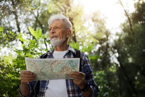 istock Senior Hiker looks to a map for direction 1276033326