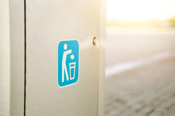 Logo on a modern waste tank on the street. Metal door. Logotype with the figure of a man throwing garbage in the trash can.