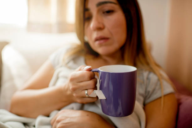 istock Young woman with cup, sitting at home on sofa 1276057061