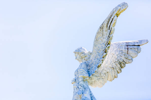 istock Angel, old statue of angle, side view, light blue sky background with copy space 1276076653