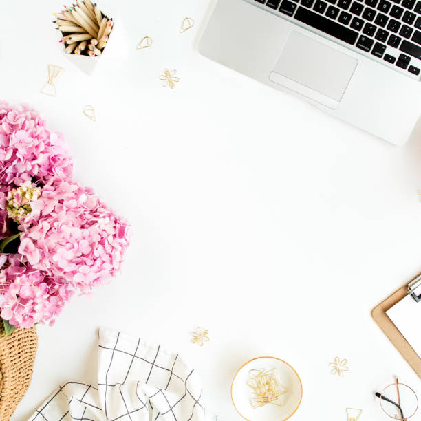 istock Workspace with clipboard, laptop, bouquet hydrangea, accessories on white background. Stylized women's desk. Flat lay. Top view 1276080540