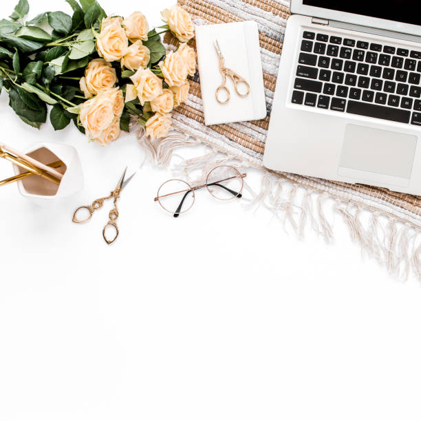 istock Female workspace with laptop, roses flowers, golden accessories, diary, computer, glasses on white background. Flat lay women's office desk. Top view 1276093392