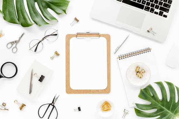 istock Home office workspace mockup with laptop, tropical leaves Monstera, clipboard, notebook and accessories on white background. Flat lay, top view 1276116566