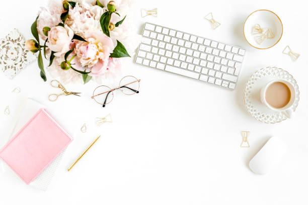 istock Flat lay women's office desk. Female workspace with computer, pink peonies bouquet, accessories on white background. Top view feminine background 1276122223