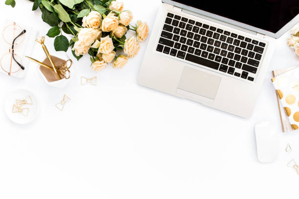 istock Female workspace with laptop, roses flowers, golden accessories, diary, computer, glasses on white background. Flat lay women's office desk. Top view 1276128876