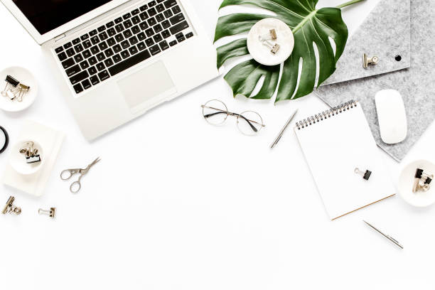 istock Home office workspace mockup with laptop, tropical leaves Monstera, clipboard, notebook and accessories on white background. Flat lay, top view 1276140769