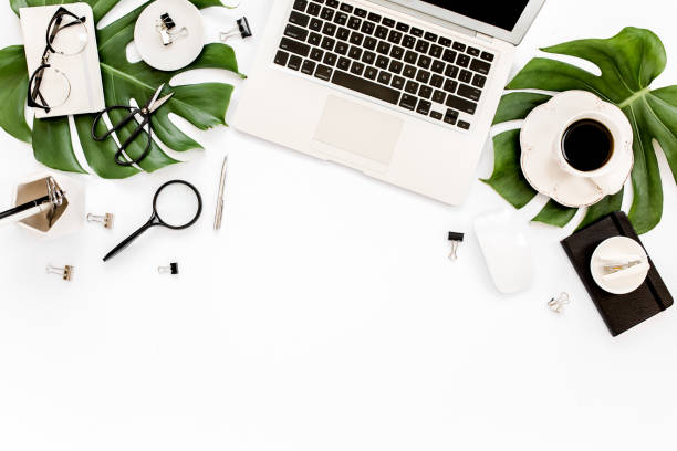 istock Home office workspace mockup with laptop, tropical leaves Monstera, clipboard, notebook and accessories on white background. Flat lay, top view 1276147217