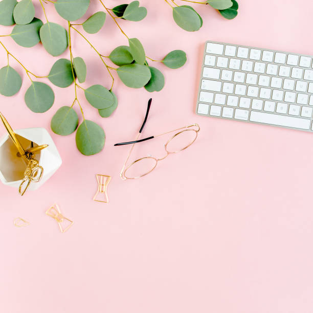 istock Office table desk with computer, green leaves eucalyptus, clipboard, golden accessories, diary, glasses. Magazines, social media. Top view. Flat lay 1276152616