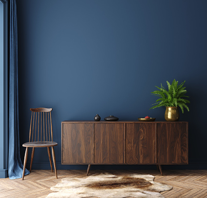 Commode with chair and decor in living room interior, dark blue wall mock up background