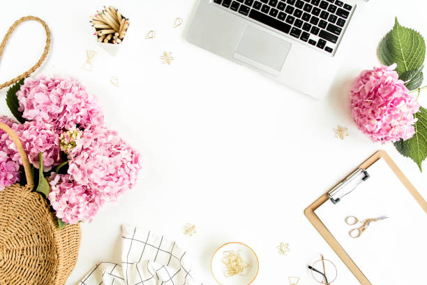 istock Workspace with clipboard, laptop, bouquet hydrangea, accessories on white background. Stylized women's desk. Flat lay. Top view 1276183467