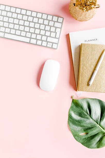 istock Flat lay home office desk. Female workspace with computer, tropical palm leaves Monstera, accessories on pink background. Top view background 1276212880