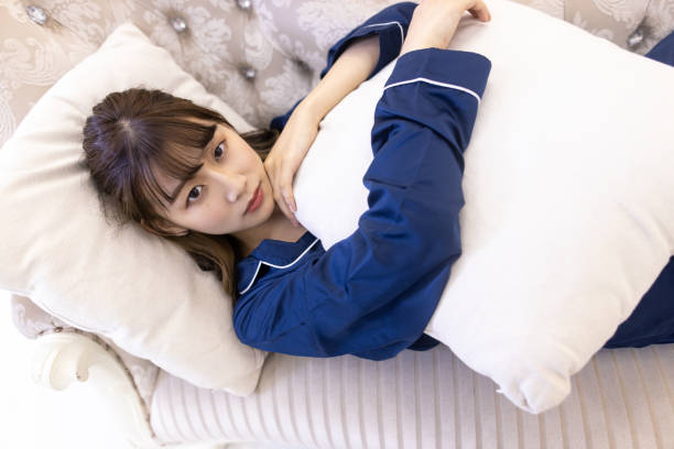 istock Young woman relaxing on couch - looking at camera 1276224890