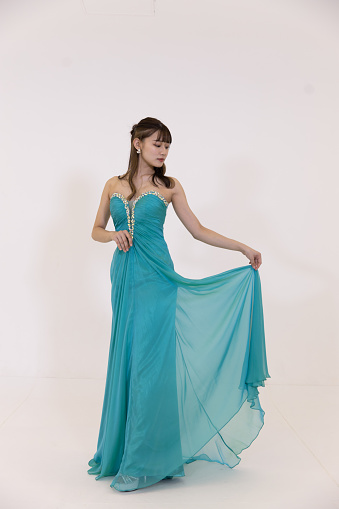 Full length portrait of beautiful young women in elegant turquoise blue dress