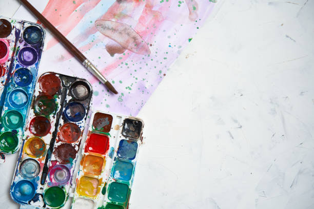 istock Set of watercolor paints on white background. Brushes drawing. Creative background. School for teaching drawing. 1276256651
