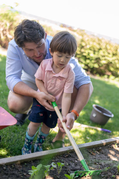 istock Young boy helping his dad do some landscaping 1276257085
