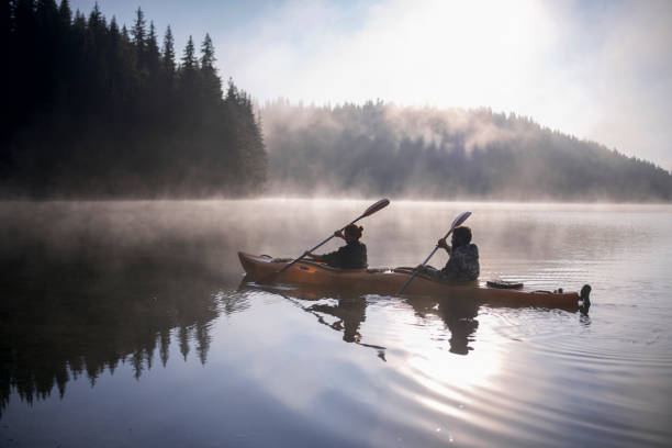 le garçon et la fille voyagent avec leur bateau de kayak aux montagnes - autumn glory photos et images de collection