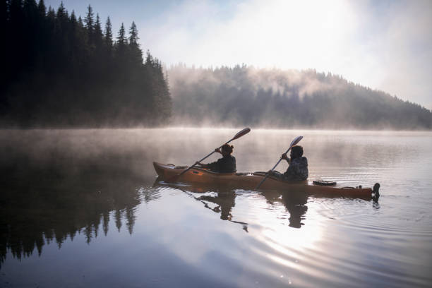 ragazzo e ragazza stanno viaggiando con la loro barca in kayak in montagna - kayaking kayak river sport foto e immagini stock