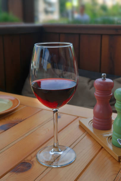 istock Glass with dry red wine on a table in a cafe close-up. 1276303717