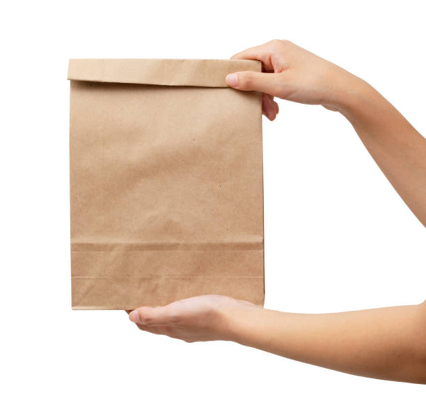 istock A woman's hand holding a brown paper bag 1276312230