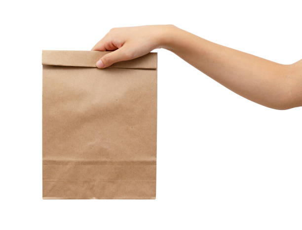 istock A woman's hand holding a brown paper bag