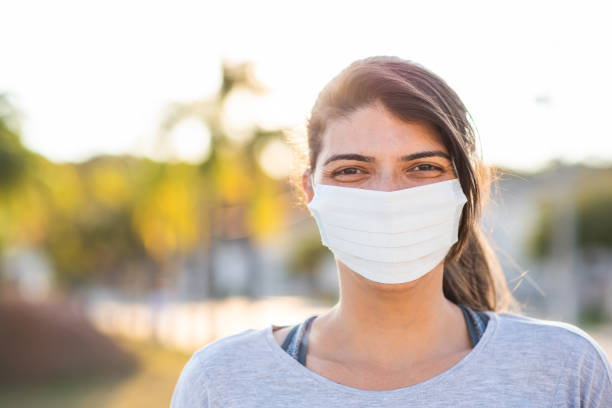 istock Smiling woman behind face protection mask 1276348881