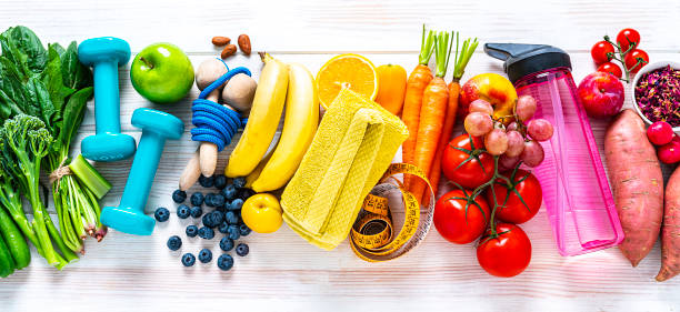 運動とビーガンの食べ物:白い背景にライボウ色の果物、野菜やフィットネスアイテム - fruit tomato vegetable full frame ストックフォトと画像