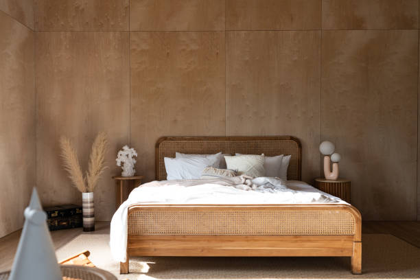 istock Stylish Bedroom corner with rattan headboard and bed with soft pillows setting with white pillows plywood wall on the background / cozy interior design / modern interior 1276373681