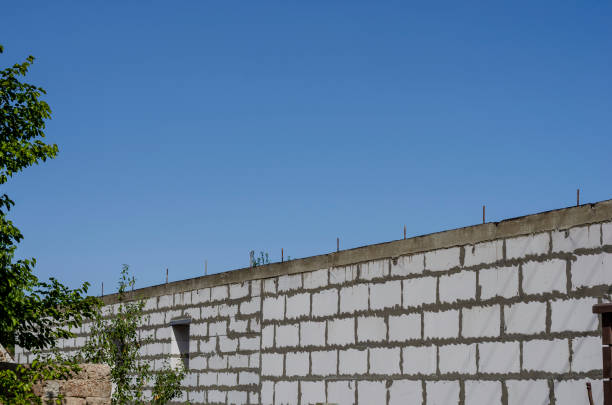 istock Stone wall with concrete and fittings against the blue sky. 1276376933