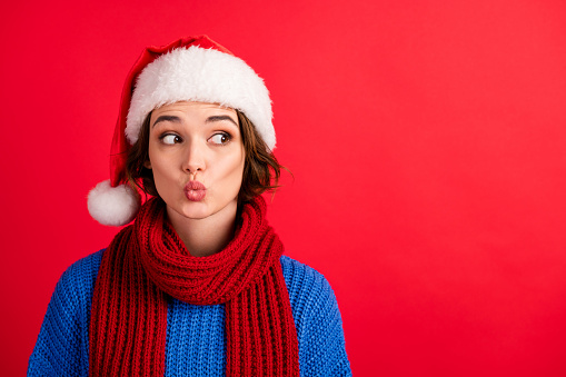 Portrait of curious surprised girl listen christmas season sales news look, copyspace make her lips pouted plump wear pullover santa claus headwear isolated shine red color background