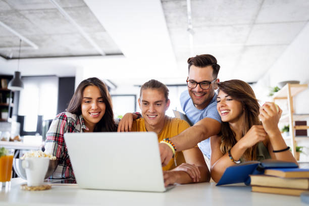 Multiracial young people enjoying group study at table. Group of young people enjoying group study. Happy university students with books and laptop for researching information for their project. sports team stock pictures, royalty-free photos & images
