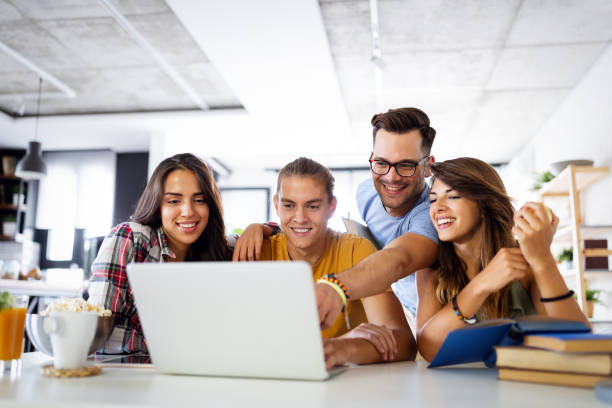 Multiracial young people enjoying group study at table. Group of young people enjoying group study. Happy university students with books and laptop for researching information for their project. group of students stock pictures, royalty-free photos & images