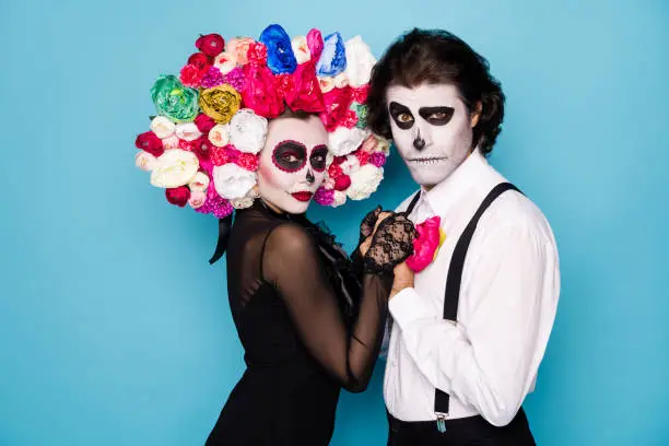 Profile photo of spooky couple man girl lady married hold hands dance, passion tango wear trendy black dress death costume facial decor roses headband suspender isolated blue color background