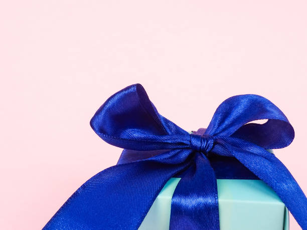 istock gift box with blue ribbon on light background, minimalism, space for text and design 1276384452