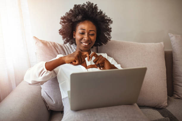 istock Young woman making heart shape symbol looking at laptop. 1276385599