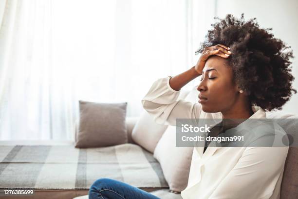 Shot Of A Young Woman Suffering From A Headache Stock Photo - Download Image Now - Emotional Stress, Women, Headache