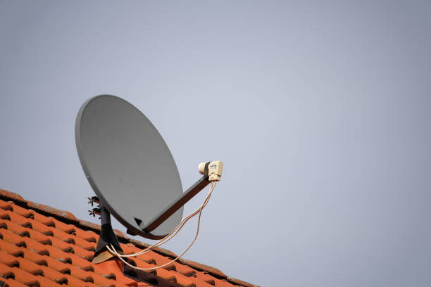 istock Satellite dish on the roof against the sky 1276386743