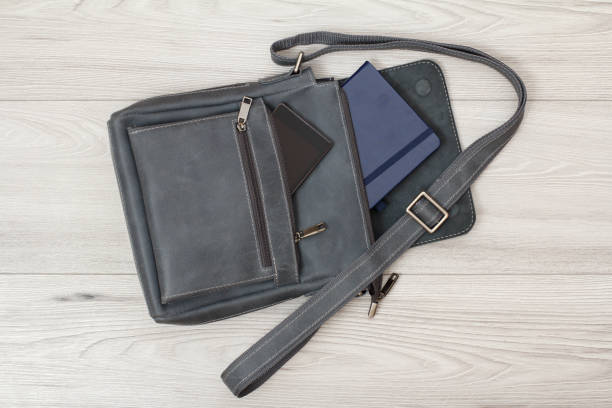 istock Leather shoulder bag for men with mobile phone and notebook on gray background 1276389721